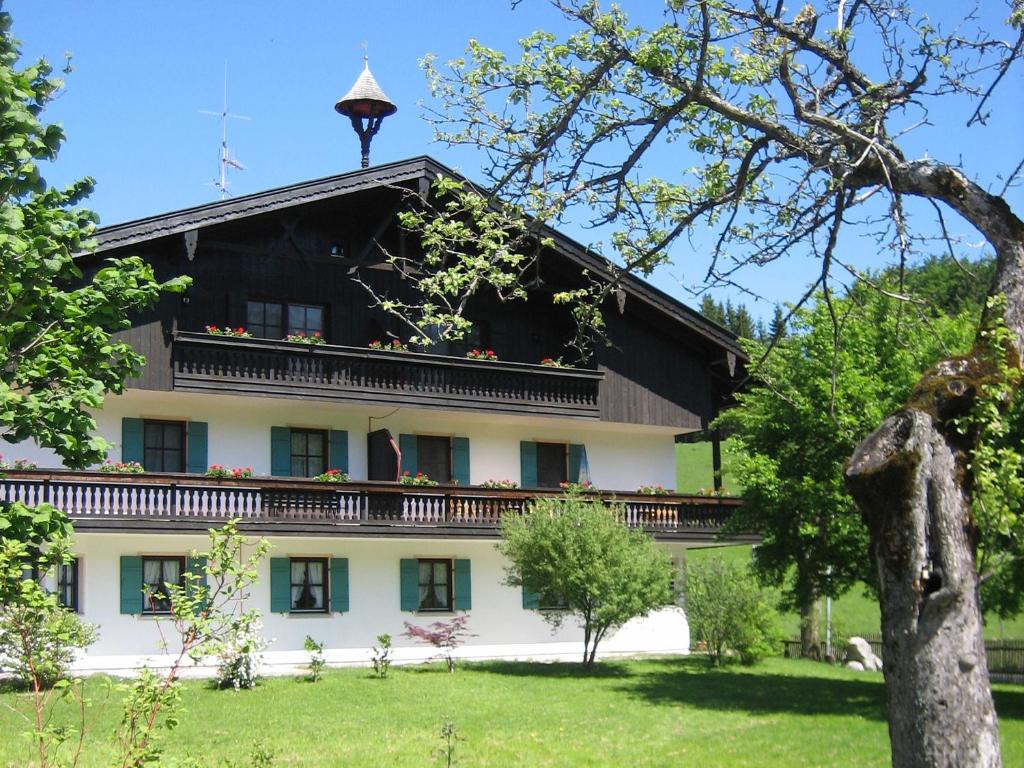 ein großes weißes Gebäude mit schwarzem Dach in der Unterkunft Gschwendtnerhof App17 Blum in Aschau im Chiemgau
