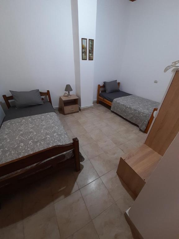 a room with two beds and a tiled floor at Adorable 2 floors two bedroom vacation maisonette in Nea Potidaea