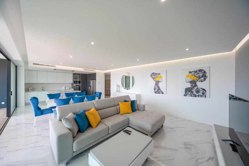 a living room with a couch and blue chairs at Luxury apartments with stunning sea views in Portimão