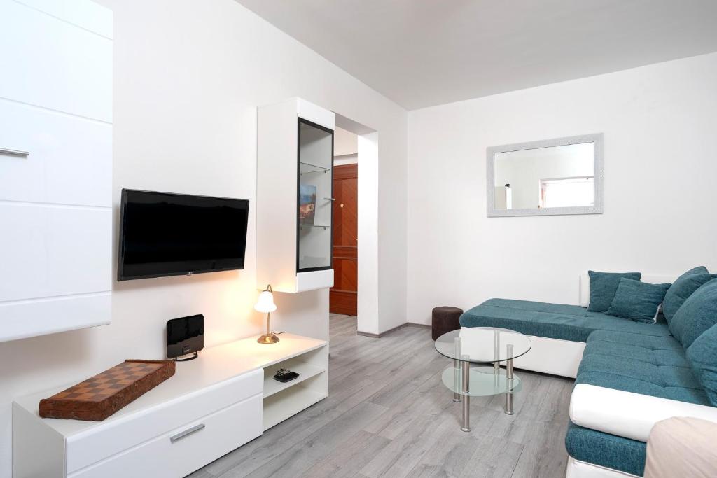 sala de estar con sofá azul y TV en Apartment Filip, en Hvar