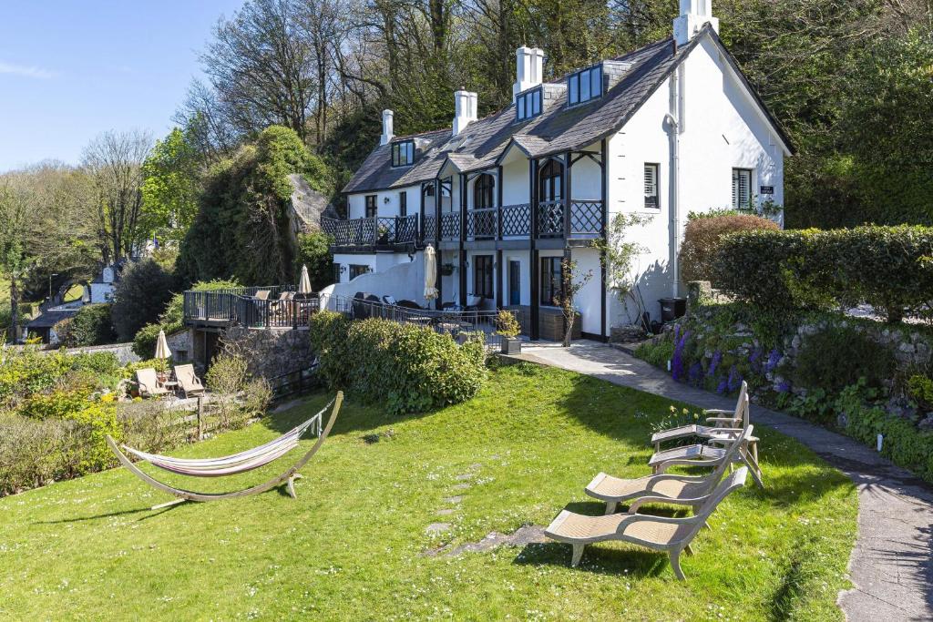 a house with a bunch of chairs in the yard at 3 Bed Cove Cottage in Torquay