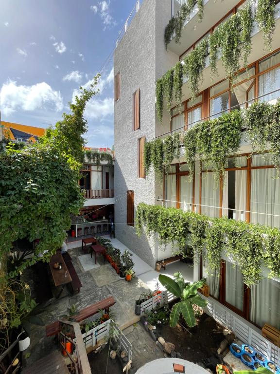 an apartment building with a courtyard with plants at Casa de Poço Guest House and Gallery in Mindelo