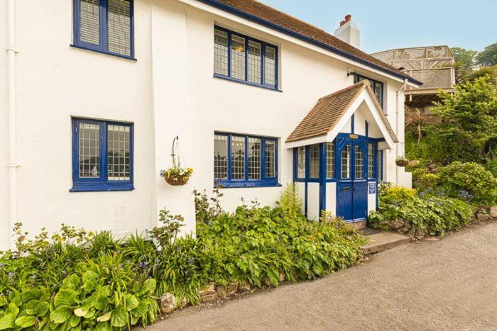 a white house with blue windows and a blue door at 4 Bed - Beach Cottage in Torquay