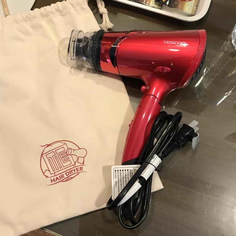 a red blow dryer sitting on top of a paper bag at 信然文旅-首學 寵物友善預訂前務必事先詢問 in Tainan