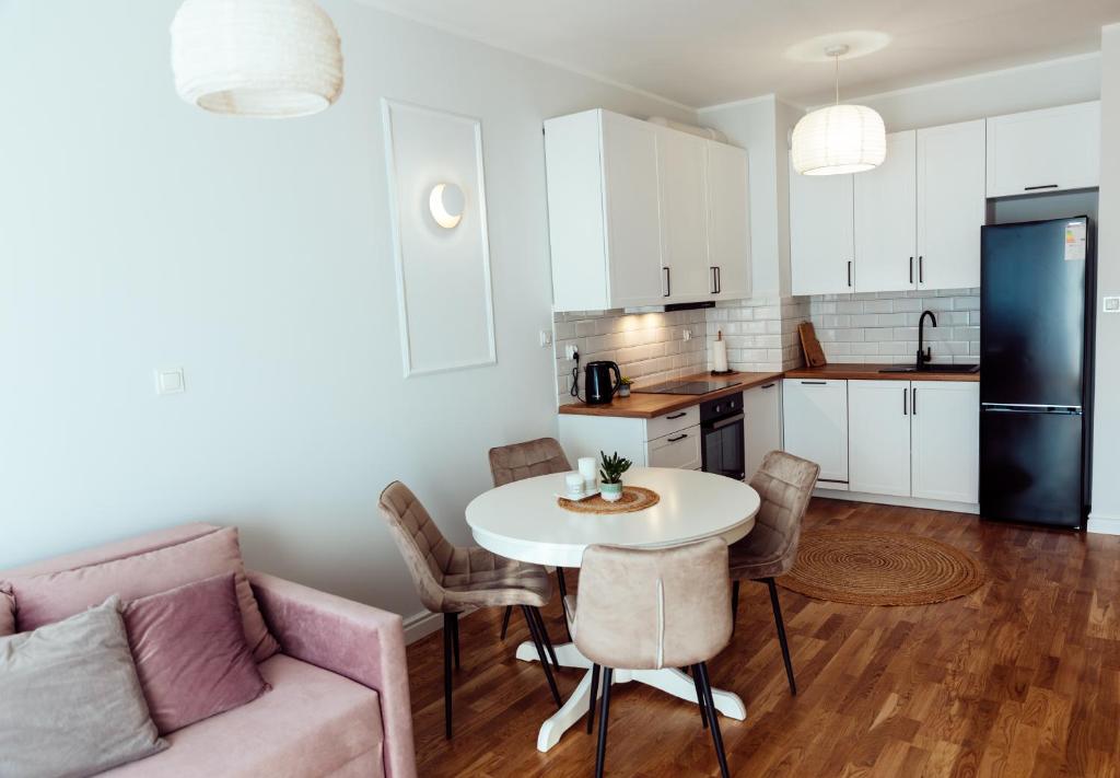 a kitchen and living room with a table and a couch at Apartamenty Termalne Dobry Klimat in Uniejow