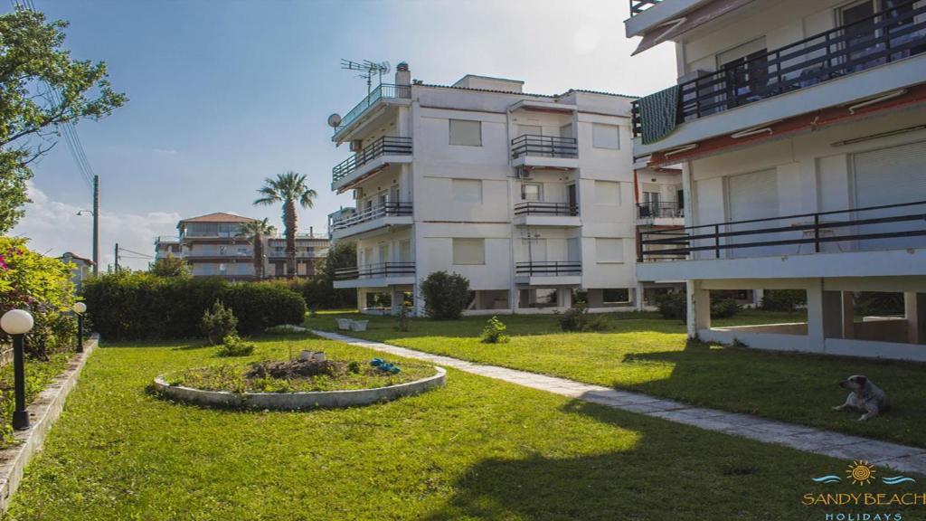 um grande edifício de apartamentos com um jardim em frente em Apartment 45m2 in Asprovalta em Asprovalta