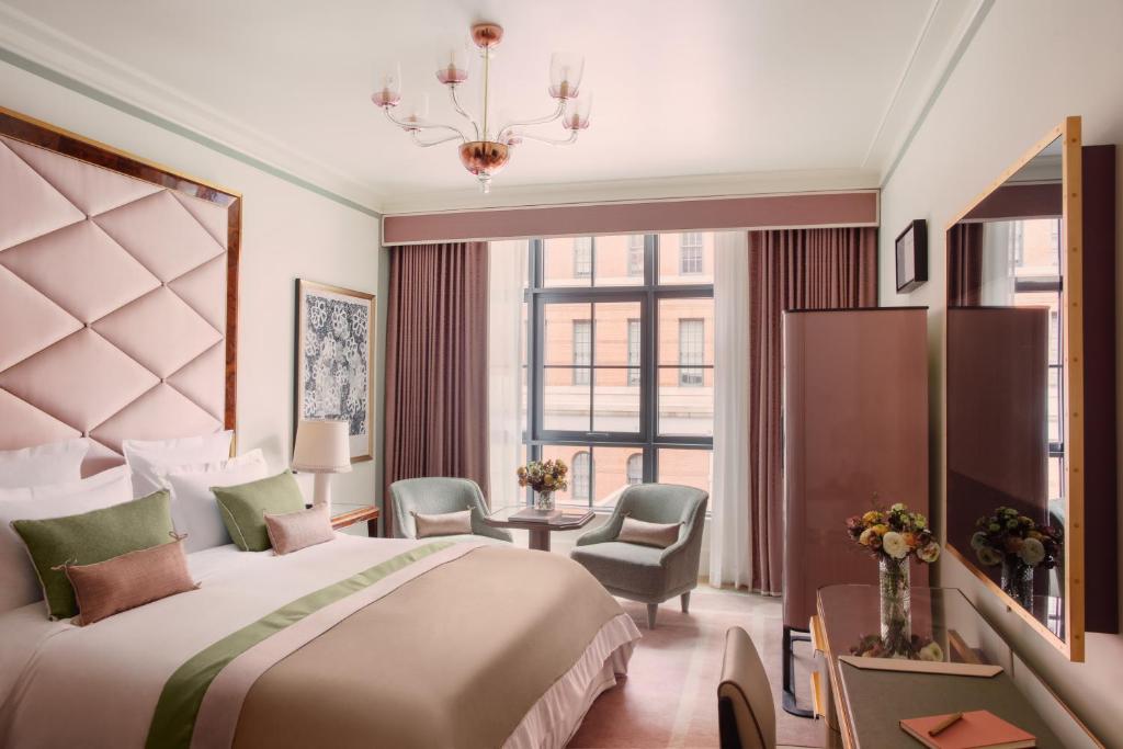 a hotel room with a bed and a large window at Hotel Barrière Fouquet's New York in New York