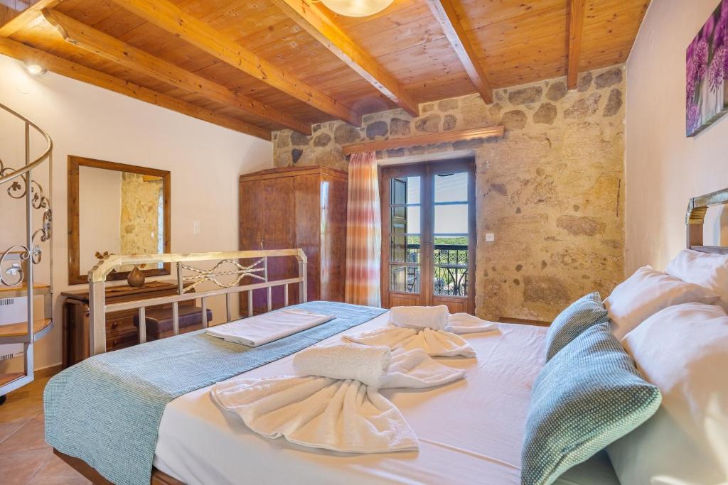 1 Schlafzimmer mit einem großen Bett und einem Badezimmer in der Unterkunft Olive Villas in Kría Vrísi