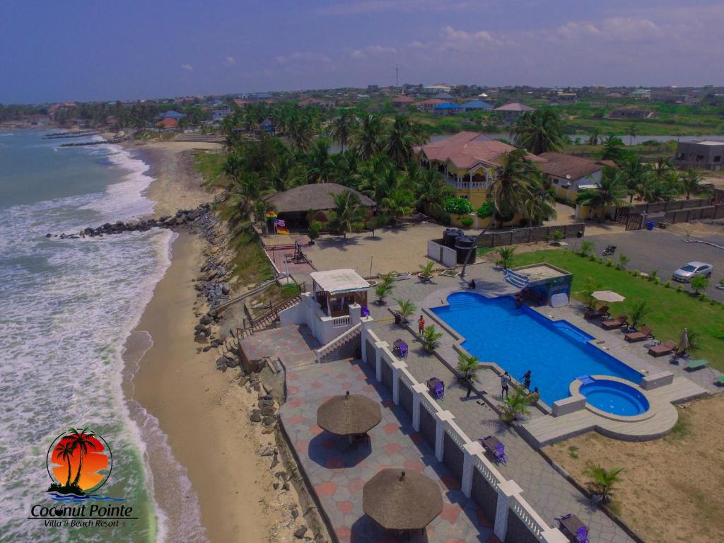an aerial view of a resort with a pool and the beach at Coconut Pointe Villa & Beach Resort in Prampram