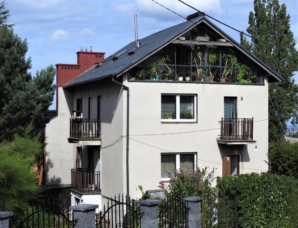 a white house with a black roof at Safari house - dom podróżnika in Gdynia