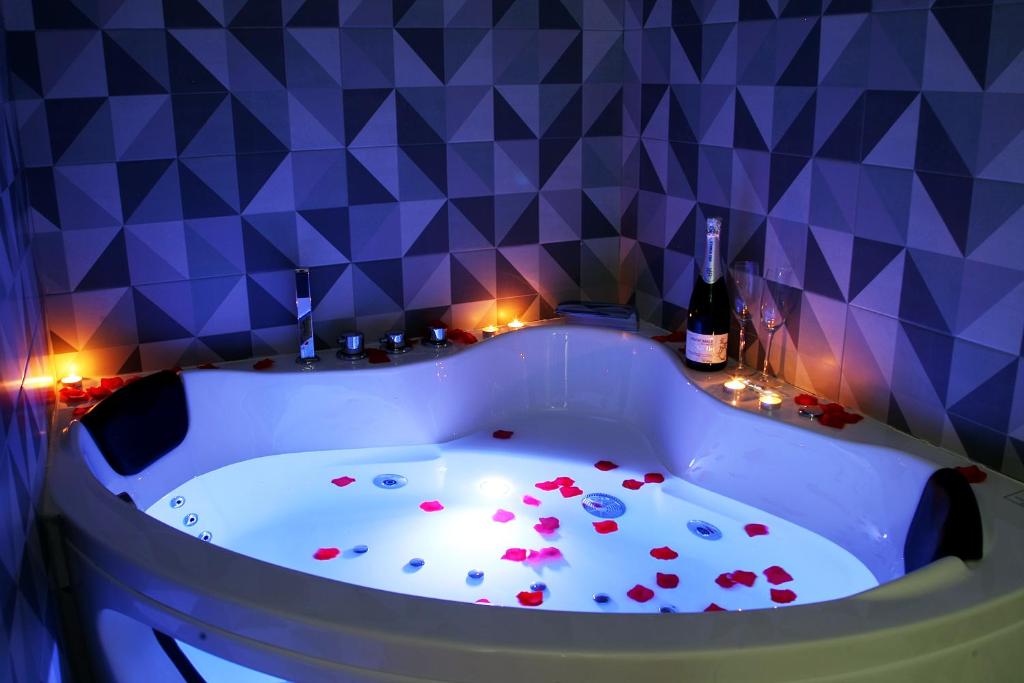 a bath tub filled with flowers in a room at Apartamentos Las trece llaves Jacuzzi bajo reserva in Merida