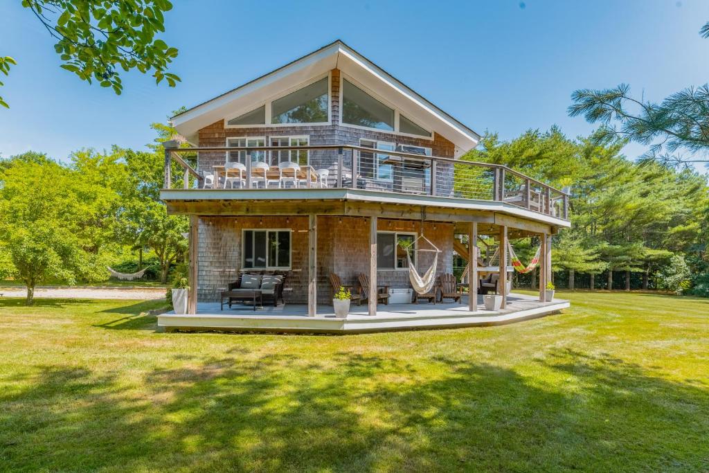 una casa con una cubierta envolvente en un césped en Montauk Private Getaway en Montauk