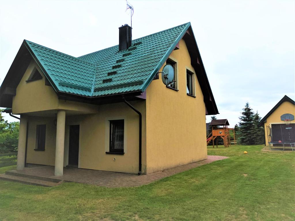 una piccola casa con un tetto verde su un cortile di Zielona Zagroda a Borek