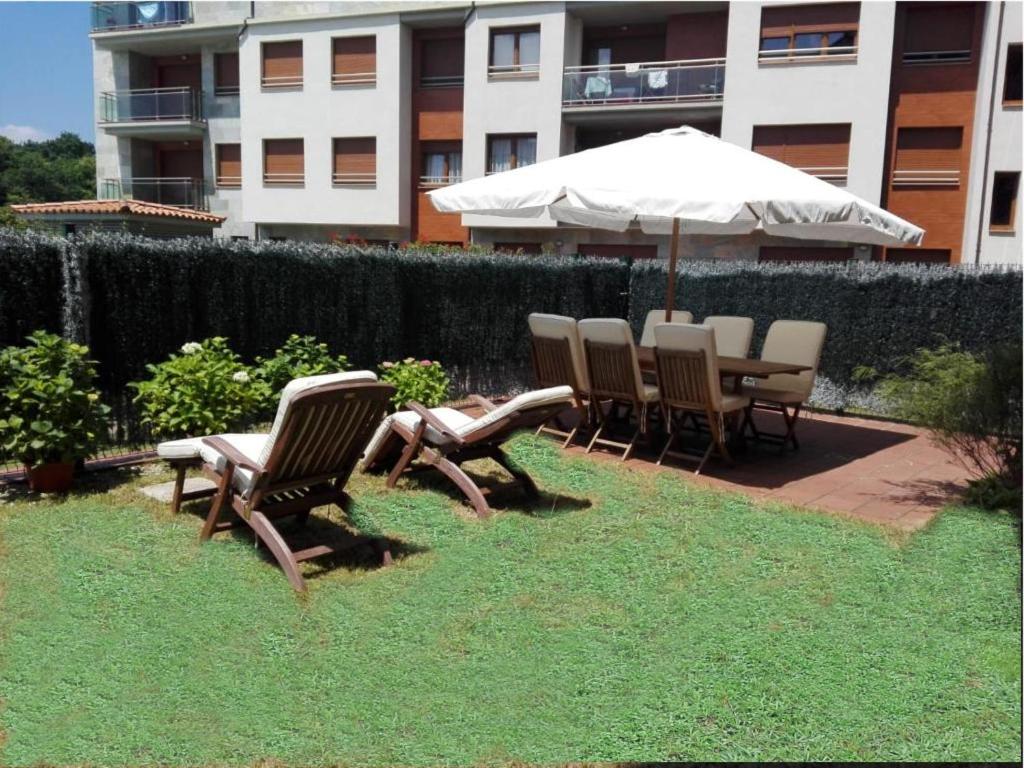 een groep stoelen en een tafel met een paraplu bij Descanso en el Sella in Cangas de Onís