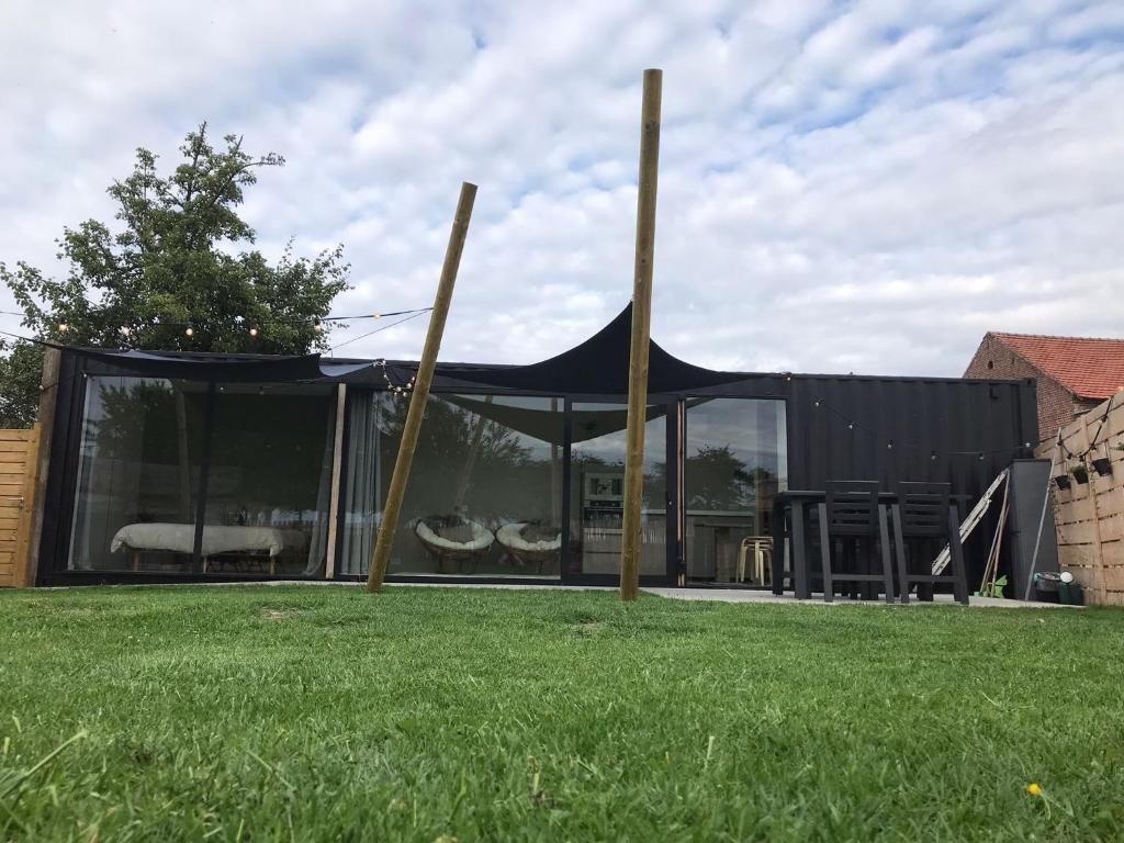 a black tent in the middle of a yard at Tussen de paarden @ De Hoeveschuur in Riemst