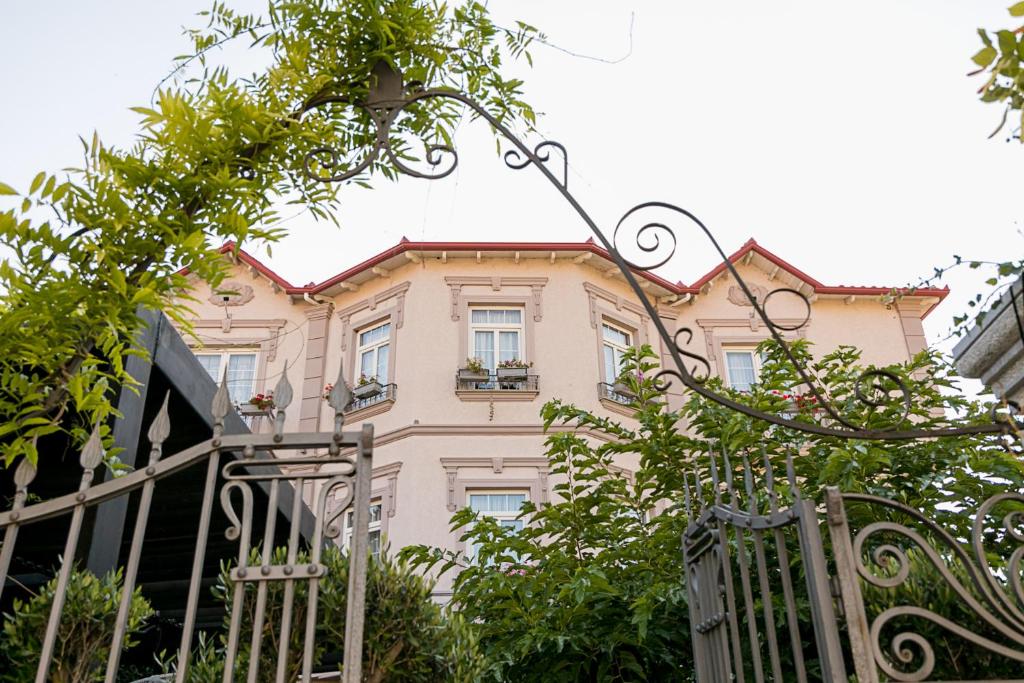 a pink house with a gate in front of it at Barba Boutique Hotel in Korçë