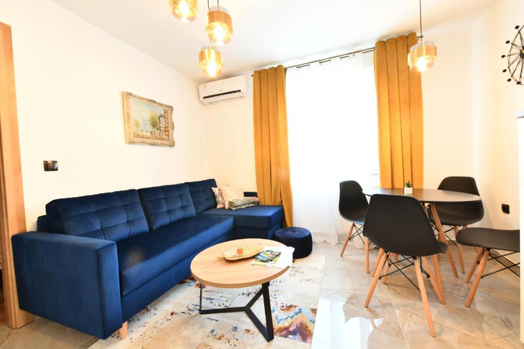 a living room with a blue couch and a table at Apartmani Brium in Rakovica