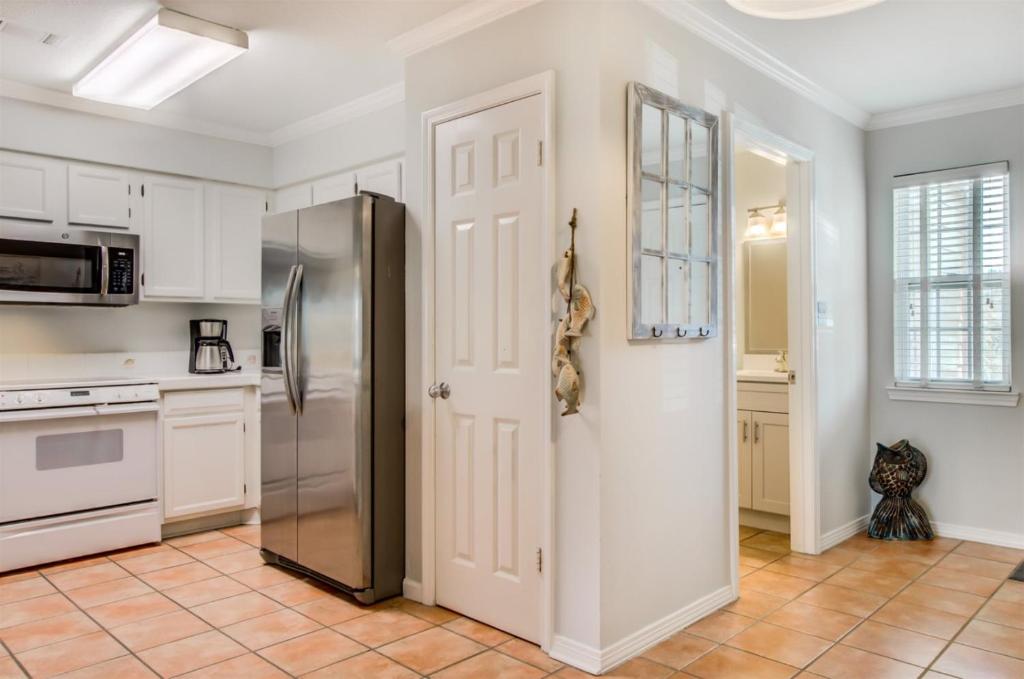 a kitchen with white cabinets and a refrigerator at 5 C, Three Bedroom Townhome in Destin