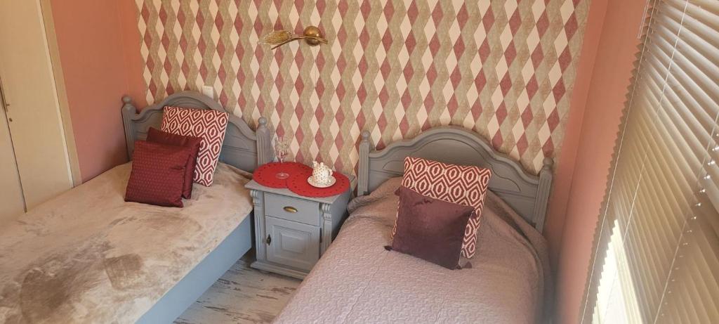 a toy bedroom with two beds and a table at Gwiazda Polarna in Olsztyn