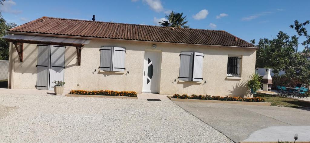 ein kleines weißes Haus mit zwei Fenstern und einer Einfahrt in der Unterkunft A L'orée du Bois in LʼÉguille