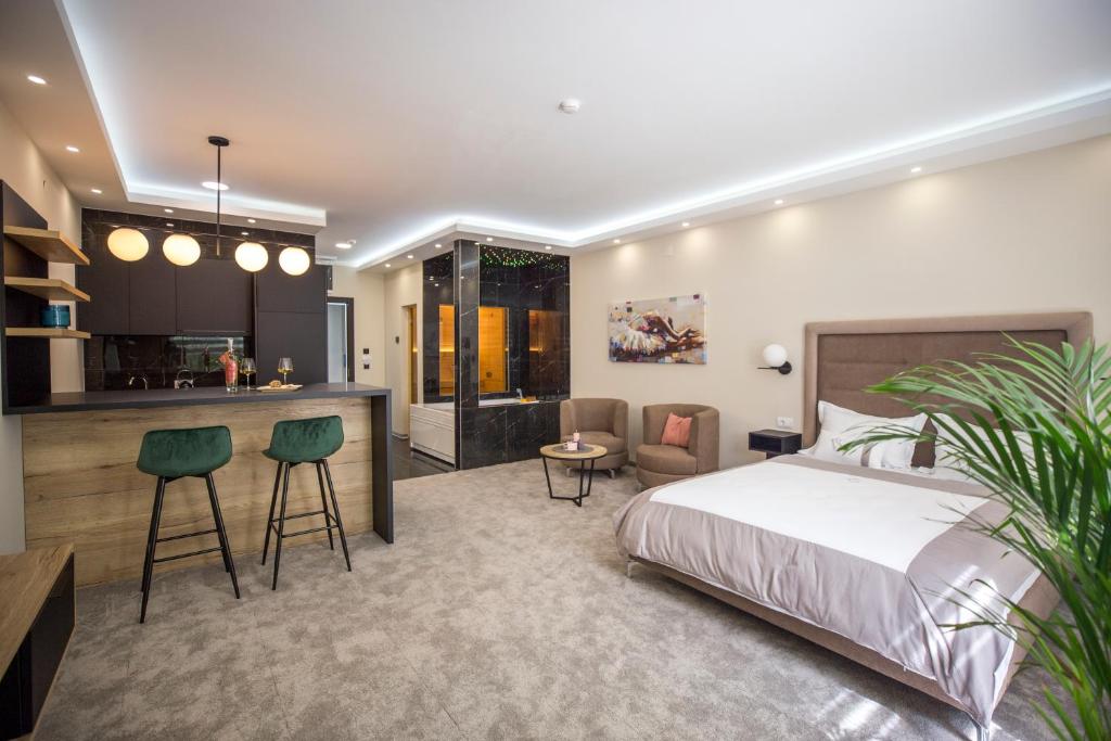 a bedroom with a large bed and a kitchen at VS Exclusive Luxury Wellness & Spa Apartmani - Vrnjačka Banja in Vrnjačka Banja