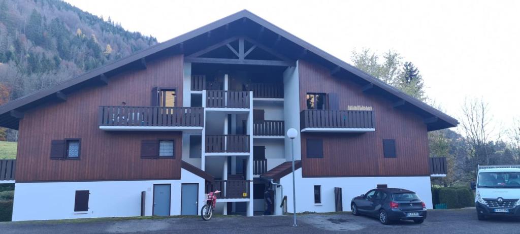 a large building with a staircase in front of it at Appartement de station rénovée avec parking in Habère-Poche