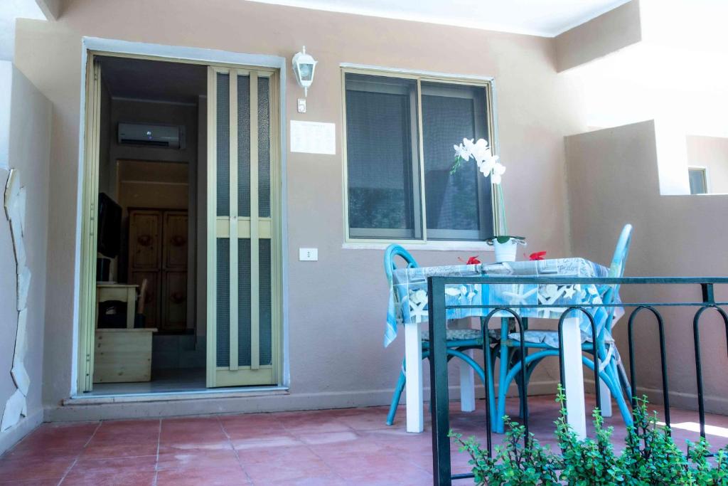 a patio with a table and chairs on a balcony at Hotel L'Oleandro in Villasimius