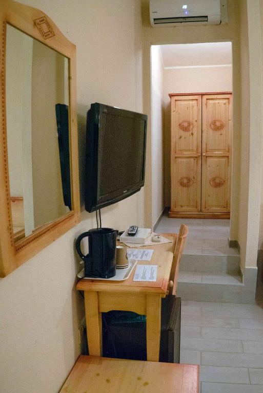 a desk with a computer monitor on a wall at Hotel L'Oleandro in Villasimius