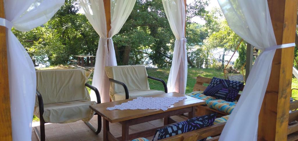 patio con sedie, tavolo e tende di Kuća za odmor Una a Dvor