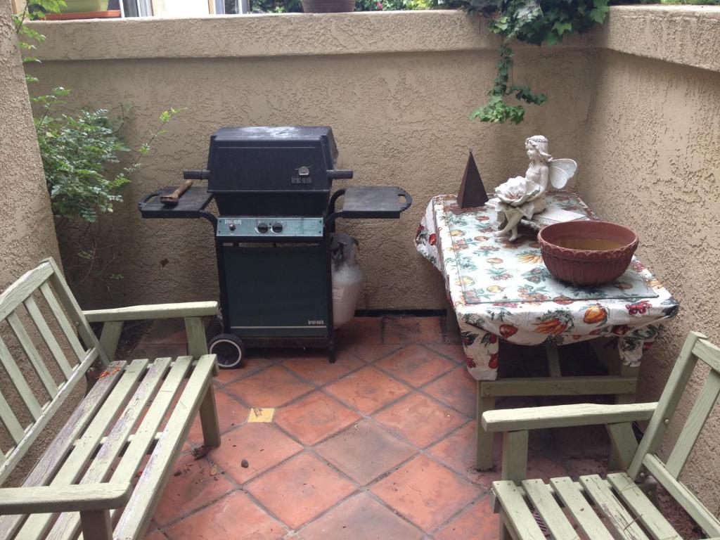 a patio with a grill and a table with two benches at Del Mar Heights Getaway in San Diego