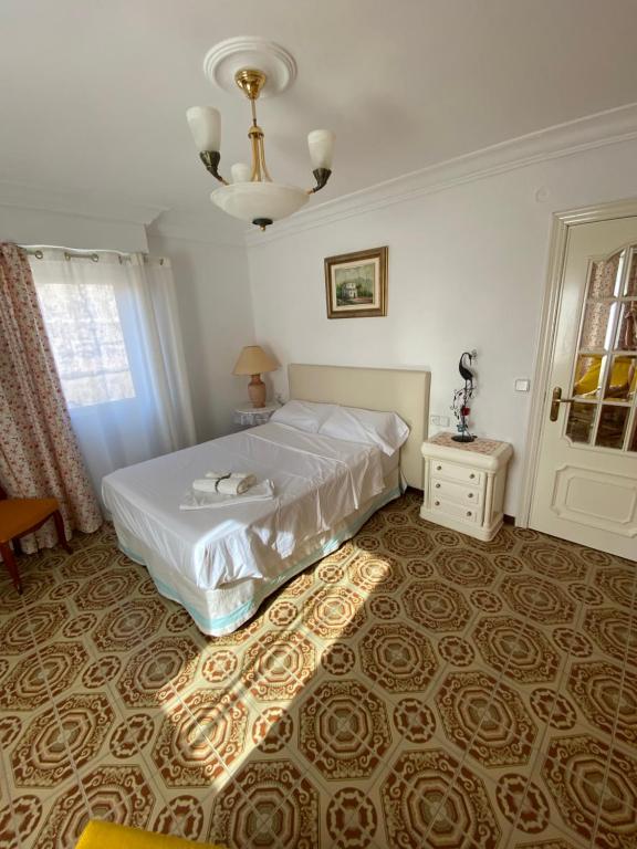 Hotel Apartamento en la playa alquiler desde 11 noches!, a bedroom with a bed and a chandelier at Apartamento en la playa alquiler desde 11 noches! in Valencia