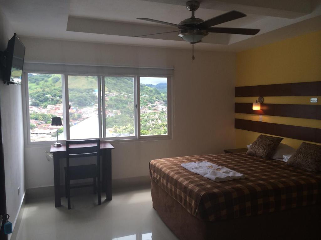 Schlafzimmer mit einem Bett und einem Deckenventilator in der Unterkunft Hotel Tijerinos in Boaco