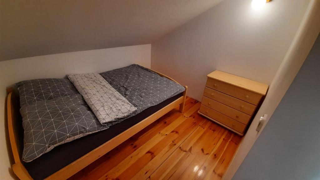 Dormitorio pequeño con cama y vestidor en Domek Między Jeziorami en Wąglikowice