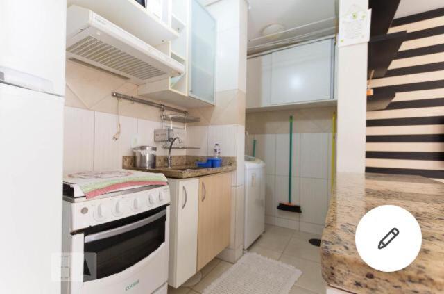 een kleine keuken met een fornuis en een spoelbak bij FlatsRose CH Flamboyant Conforto e qualidade in Goiânia
