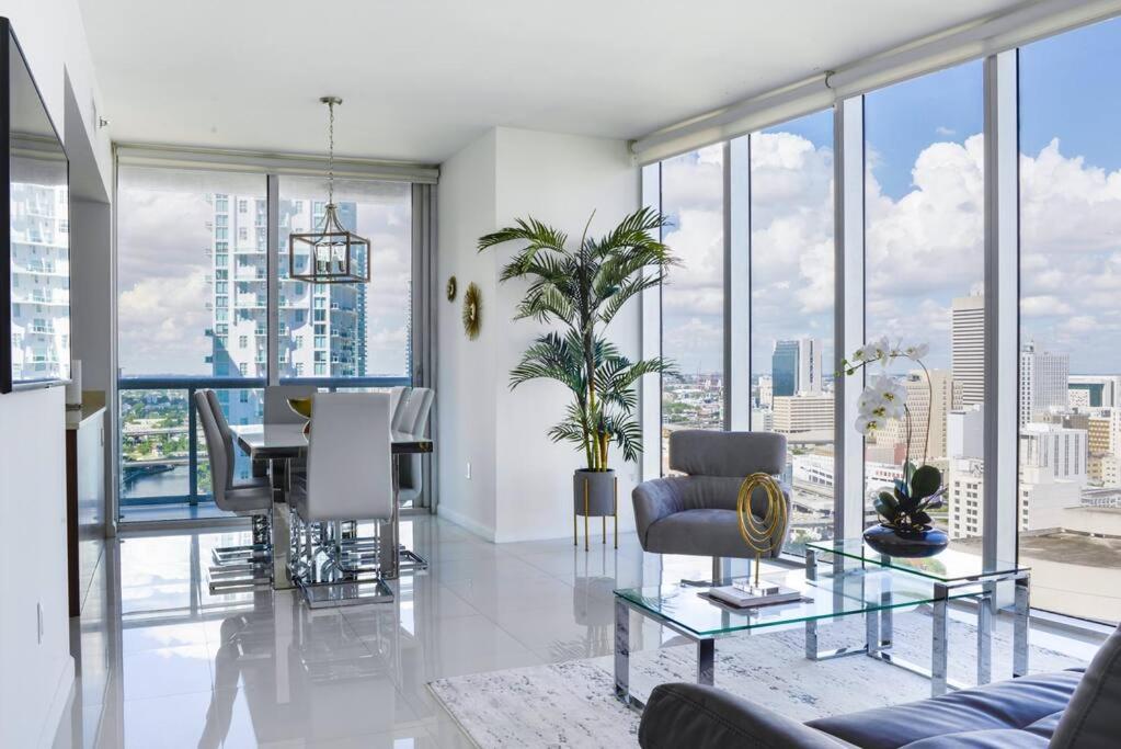 sala de estar con mesa, sillas y ventanas en Wonderful 2 BR APT With Ocean Views At Icon Brickell, en Miami