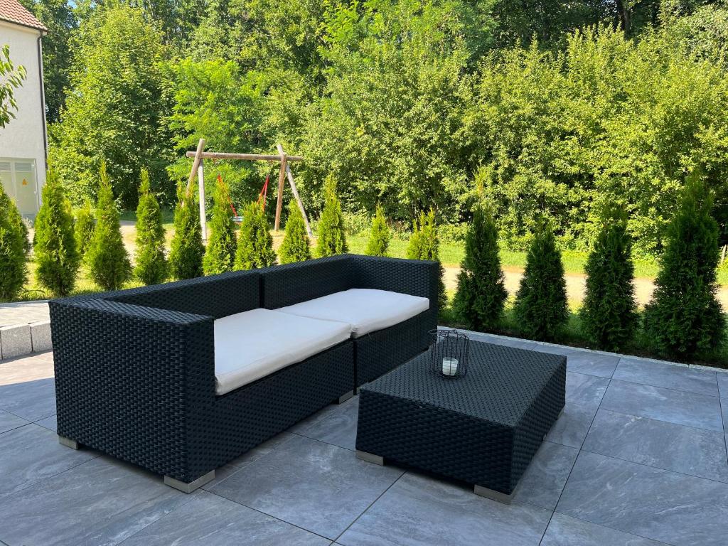 a black wicker couch and a table on a patio at Ferienwohnung Natur in Balingen