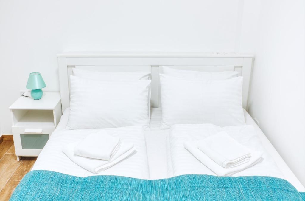 a white bed with white sheets and pillows at 365Balaton Apartmanok in Alsóörs