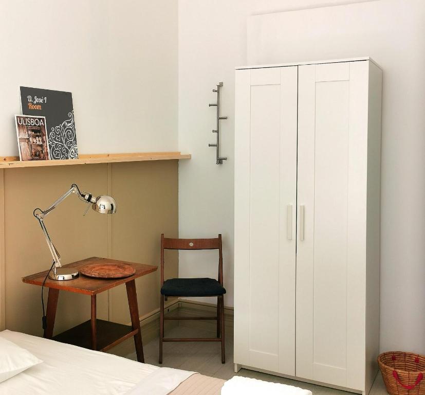 1 dormitorio con cama, escritorio y armario blanco en Ey Lisbon GuestHouse, en Lisboa