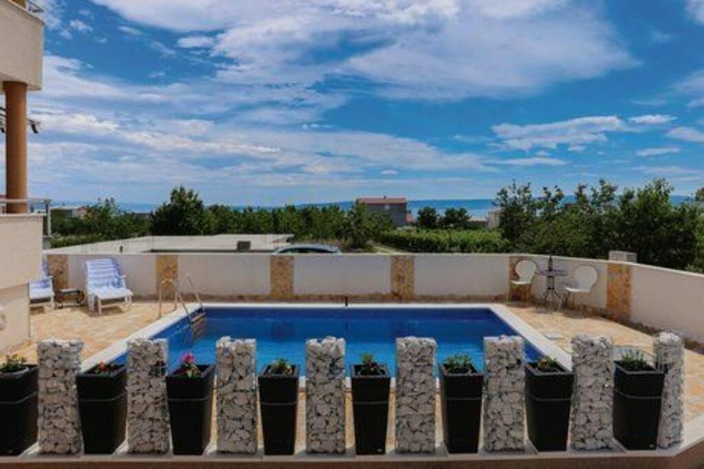 a swimming pool on the balcony of a house at Villa Golub in Kastel Stari