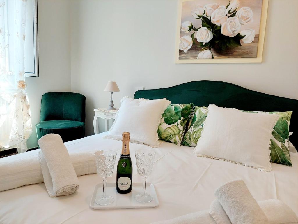un letto con una bottiglia di vino e bicchieri sopra di BBHOME Saint Paul design boutique Apartment a Roma