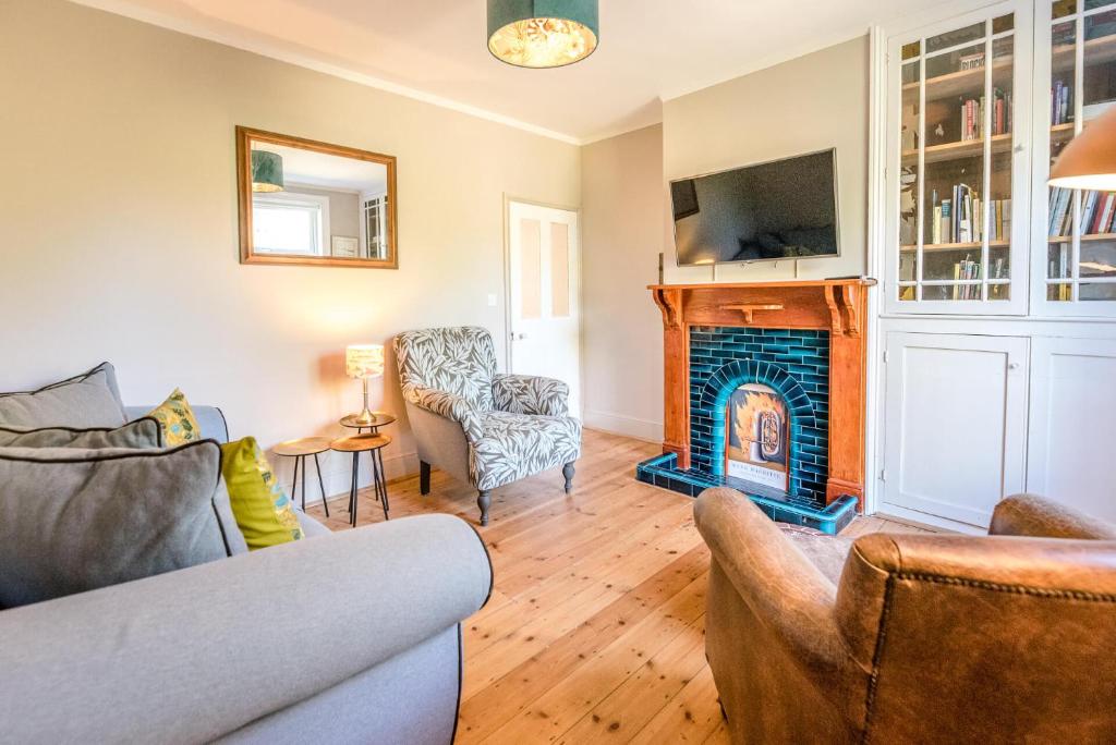 - un salon avec un canapé et une cheminée dans l'établissement Rose Cottage Halesworth Air Manage Suffolk, à Halesworth
