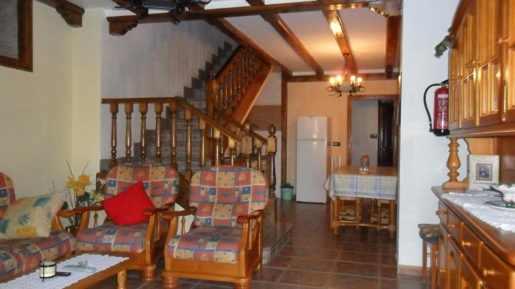 una sala de estar con algunas sillas y una escalera en Casa Rural El Arrabal en Piña de Campos