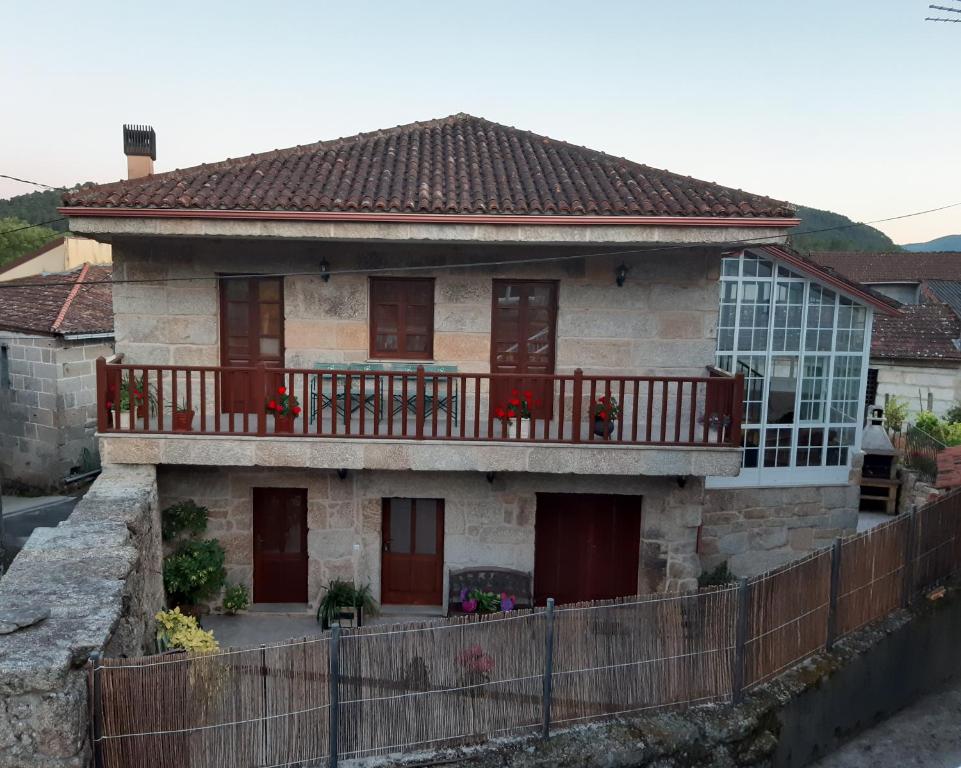 a small house with a balcony on a house at Casa Rural dos Chaos in Arnoia
