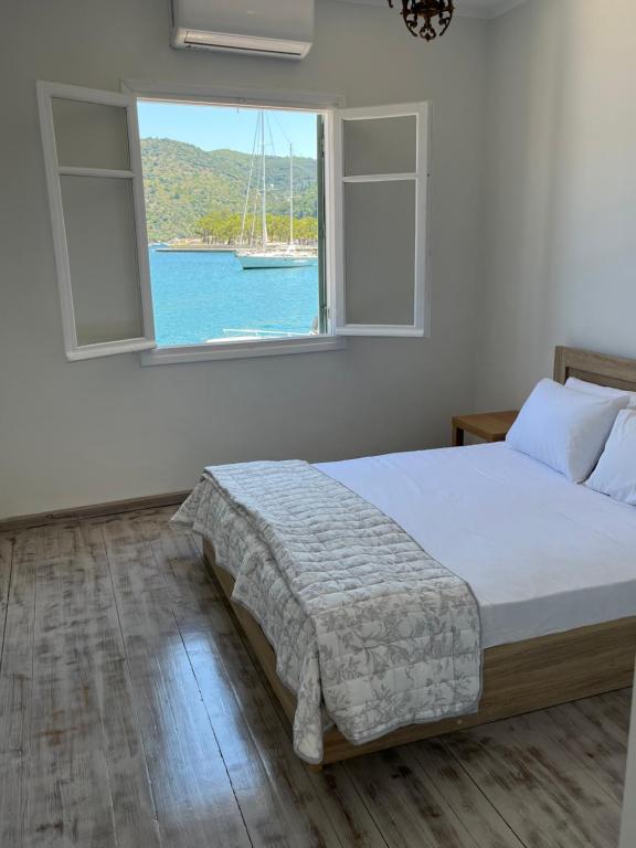 um quarto com uma cama e uma janela com um veleiro em Modern cottage on the sea em Vathi