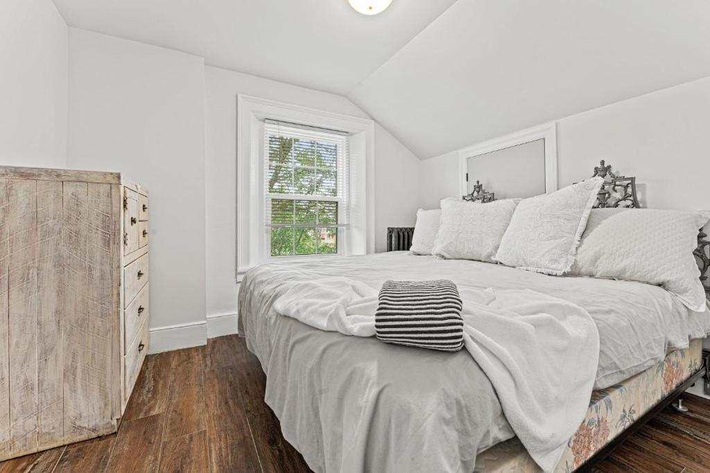 a white bedroom with a large bed and a window at Elegant 1Bdrm Apt Near Downtown Burlington Ideal for long stays U4 - Amelia in Burlington