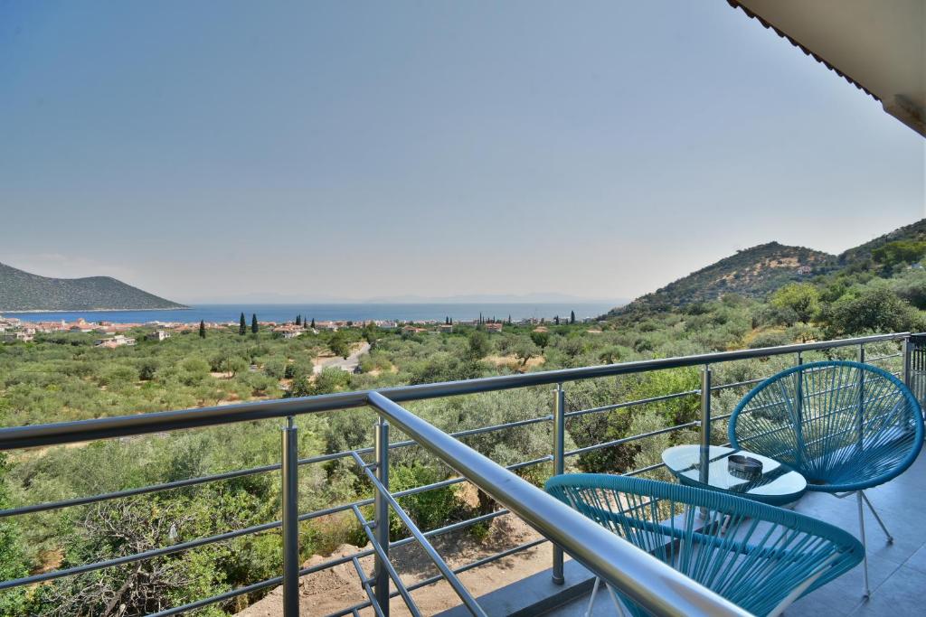 balkon z 2 krzesłami i oceanem w tle w obiekcie Konatsi Luxury Apartments w mieście Tyros