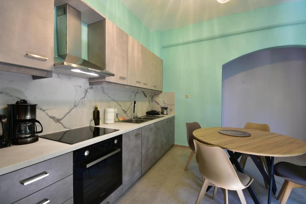 kuchnia z drewnianym stołem, stołem i krzesłami w obiekcie Konatsi Luxury Apartments w mieście Tyros