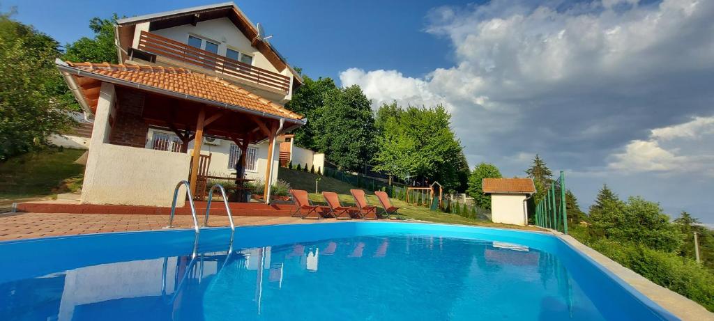 a swimming pool in front of a house at GardenLux Sarajevo in Sarajevo