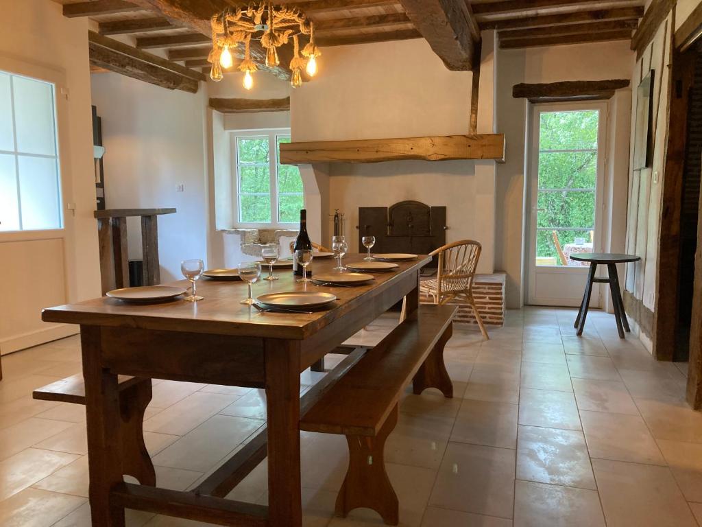 un comedor con una gran mesa de madera con copas de vino en Gite en pleine nature, en Manciet