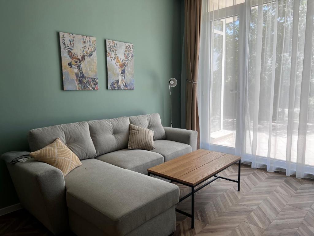 sala de estar con sofá y mesa en Las Brisas Garden Apartment, en Burgas